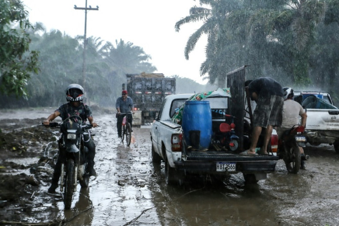 Residents leave their homes in the municipality of El Progreso, Honduras under pouring rain on October 8, 2022 before the arrival of Hurricane Julia