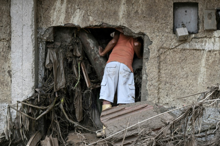 A resident searches for his missing relatives in the rubble of a house destroyed by a landslide during heavy rains in Las Tejerias, Venezuela, on October 9, 2022