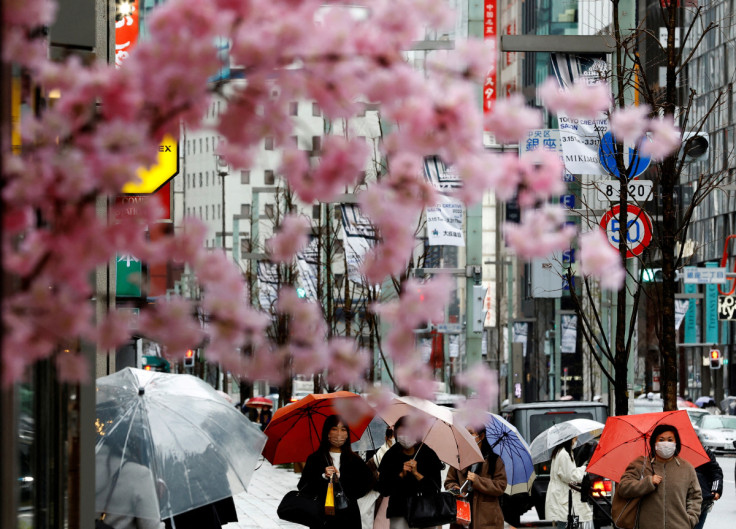 Pedestrians wearing protective face masks walk at a shopping district in Tokyo