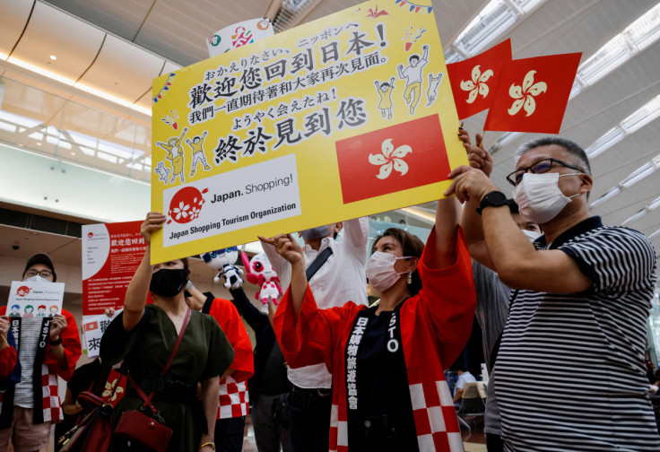 Members from Japan's shopping and tourism companies greet a group of tourists from Hong Kong during an welcome event at Haneda airport in Tokyo