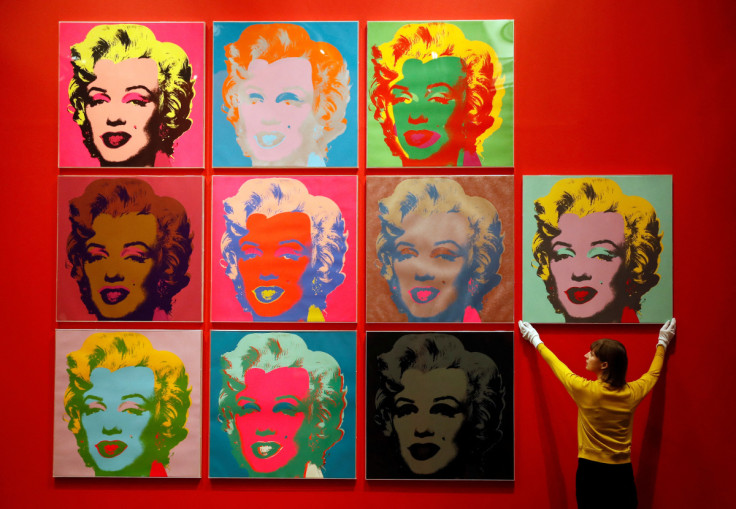 An employee poses with ten screenprints of Marilyn Monroe by Andy Warhol as part of the exhibition "American Dream: pop to the present" at the British Museum in London