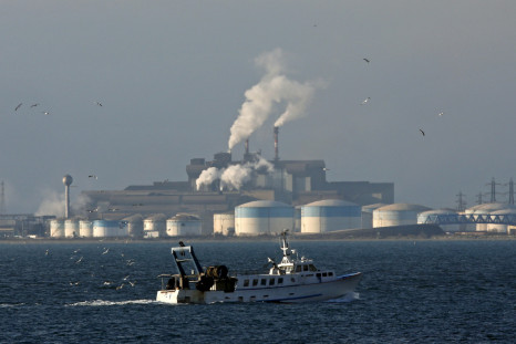 A fishing boat sails past the DPF oil refinery and the ArcelorMittal's steel plant on the site of Fos-sur-Mer near Marseille