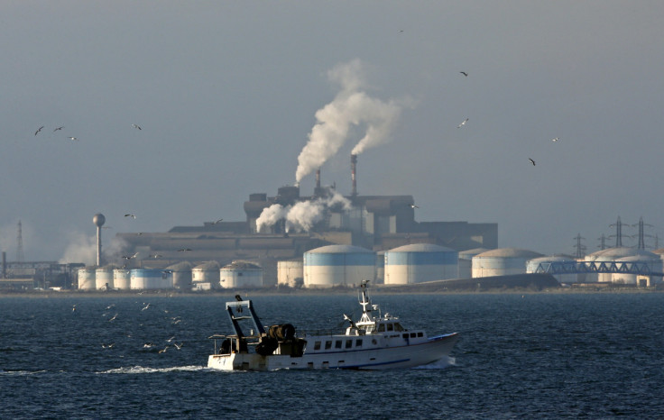 A fishing boat sails past the DPF oil refinery and the ArcelorMittal's steel plant on the site of Fos-sur-Mer near Marseille