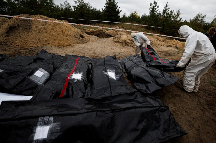 Forensics  lie down a body of an army officer they exhumed from, what Ukrainians said, a mass grave, in the newly recaptured town of Lyman