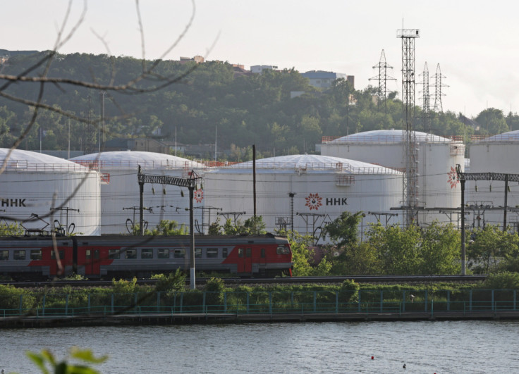 A train moves past oil tanks of the NNK-Primornefteproduct petroleum depot in the port of Vladivostok