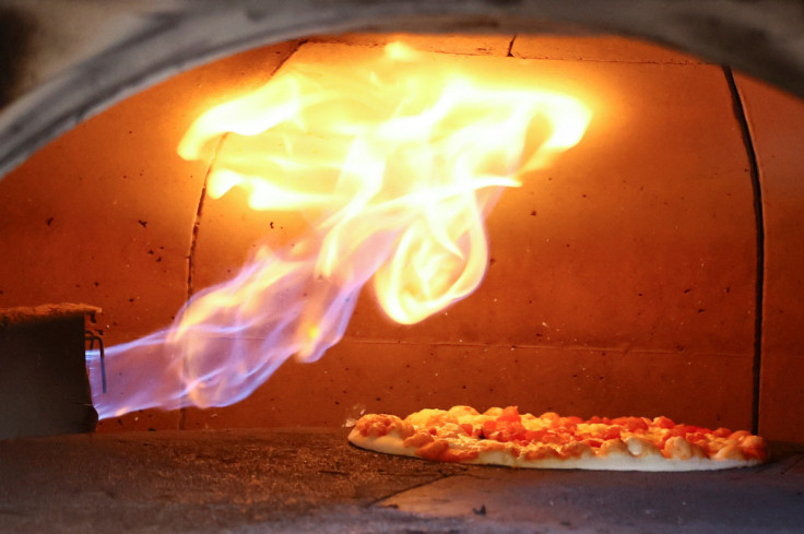 Pizza is baked in a traditional Italian pizza oven fired with natural gas, at a restaurant in Bonn