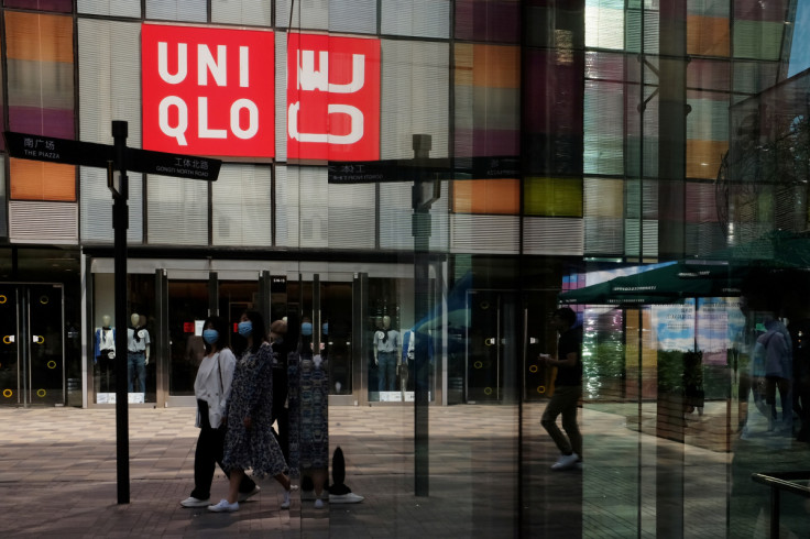 Women walk past a store of the Fast Retailing's fashion chain Uniqlo, in Beijing