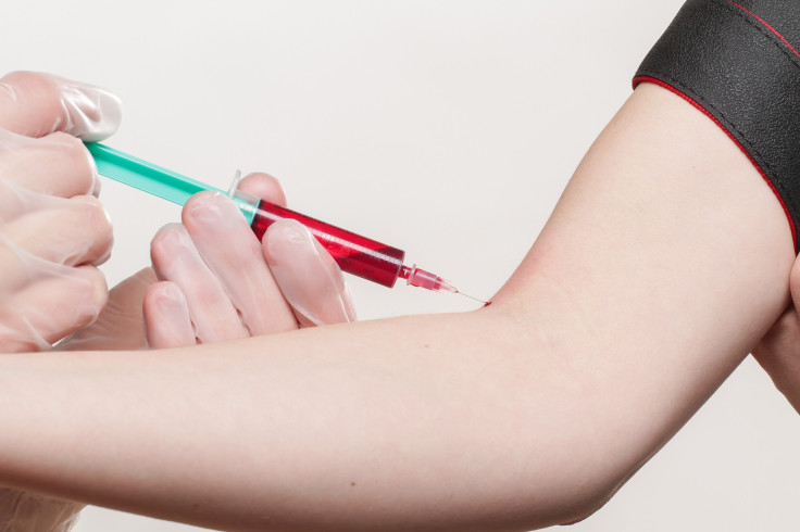 A syringe drawing blood
