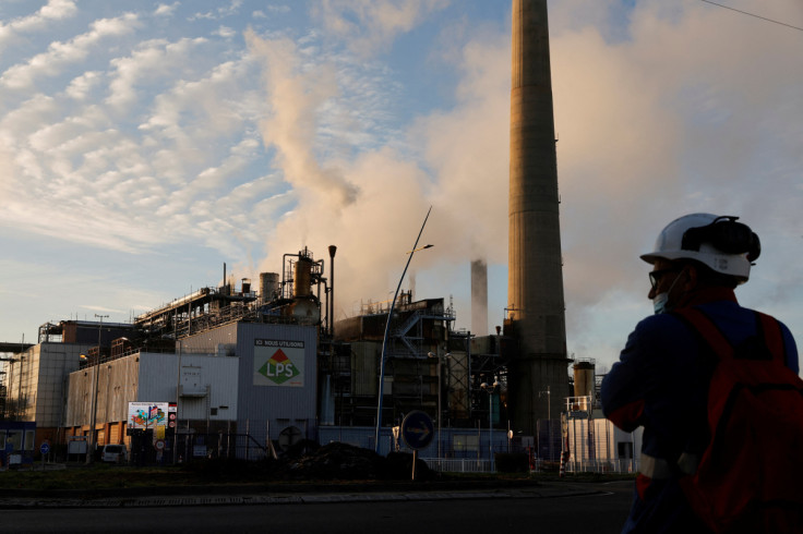 A worker stands in front of the ExxonMobil oil refinery in Port-Jerome-sur-Seine