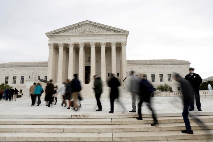 People walk across the plaza to enter the U.S. Supreme Court building on the first day of the court’s new term in Washington