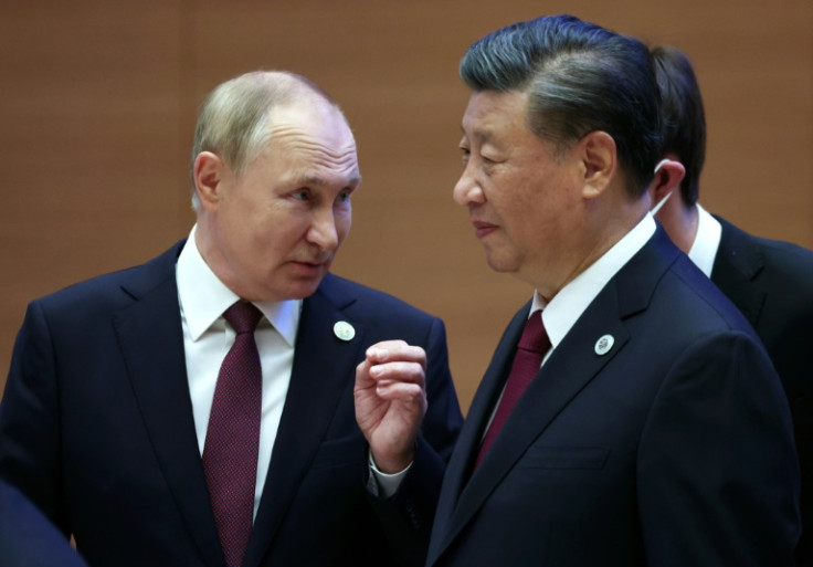 Russian President Vladimir Putin speaks to China's President Xi Jinping during the Shanghai Cooperation Organisation leaders' summit in Samarkand on September 16, 2022
