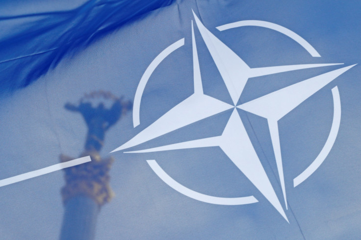 NATO flag flies in front of the Independence Monument during a rally in Kyiv