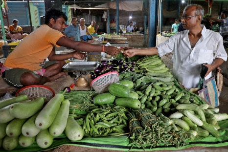 Nikhil Kumar Mondal buys vegetables from a vendor at a market on the outskirts of Kolkata