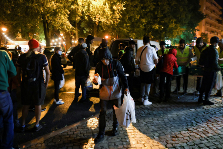 People wait in line to collect food from homeless charity CASA in central Lisbon