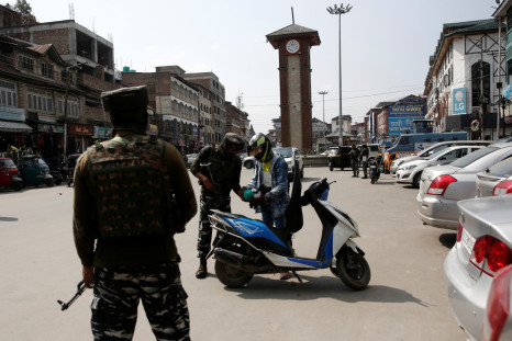 Indian Central Reserve Police Force personnel check the bags of a scooterist, in Srinagar