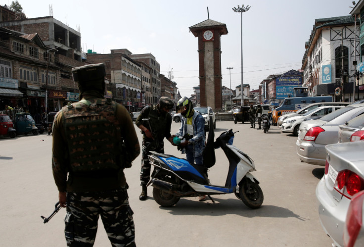 Indian Central Reserve Police Force personnel check the bags of a scooterist, in Srinagar