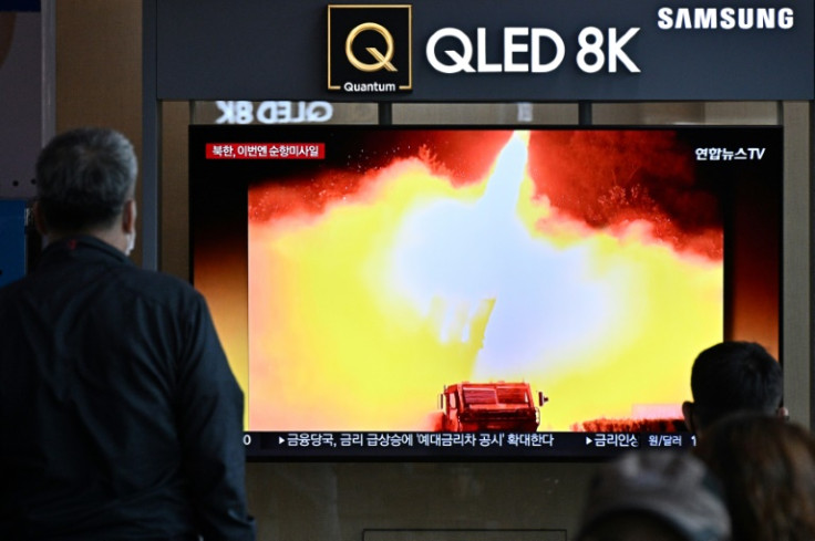 Bystanders in a Seoul railway station watch a news broadcast showing a photo of a recent North Korean missile test