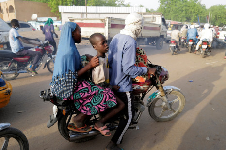 People ride a motorcycle taxi along the market in N'djamena
