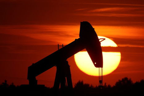The sun sets behind an oil pump-jack outside Soudron