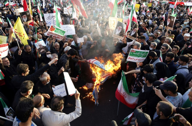 Iranian pro-government protesters burn flags of the US, Israel and Britain