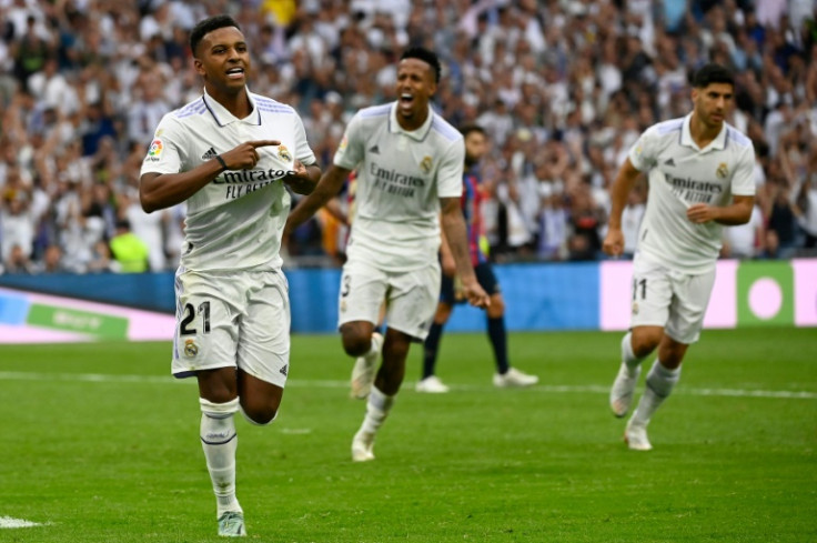 Real Madrid's Brazilian forward Rodrygo (L) celebrates after scoring his team's third goal against Barca