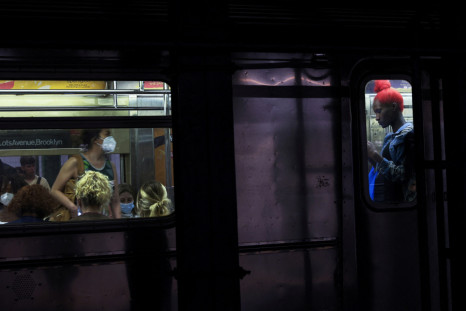 People are seen on board a subway at the 42nd street station in New York City