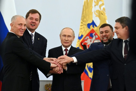 Russian-backed separatist leaders from Ukraine join hands with Russian President Vladimir Putin at a Kremlin ceremony on September 30, 2022