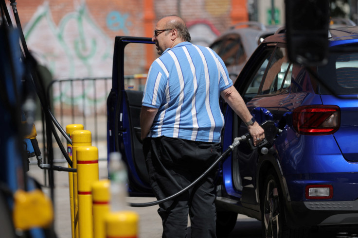 A person puts gas in a vehicle at a gas station in Manhattan, New York City