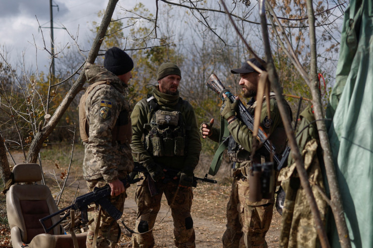 Ukrainian servicemen talk at a position on a frontline in Mykolaiv region