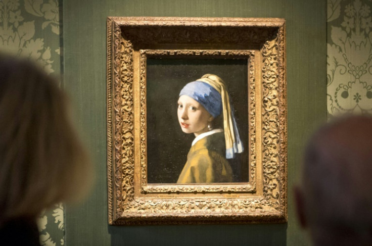 Two activists glued themselves to Johannes Vermeer's 'Girl with a Pearl Earring' and the adjoining wall, but the artwork was behind glass and undamaged