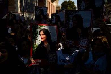 Protestors hold pictures of Iranian Mahsa Amini as they take part in a rally outside the Iranian consulate in Istanbul on September 29, 2022
