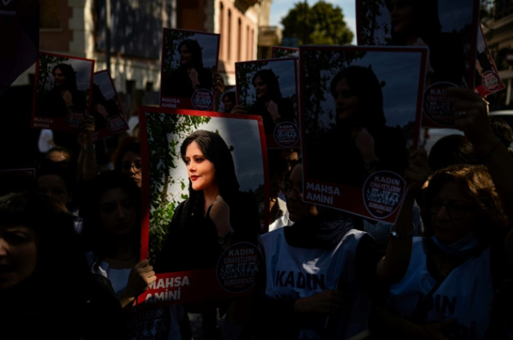 Protestors hold pictures of Iranian Mahsa Amini as they take part in a rally outside the Iranian consulate in Istanbul on September 29, 2022