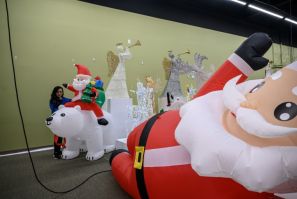 A worker inflates a Santa Claus decoration a Christmas decorations showroom of the National Tree Company in New Jersey on October 26, 2022.