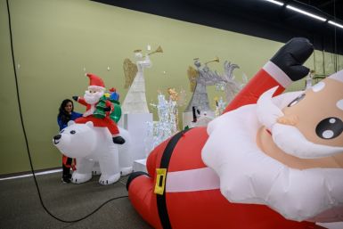 A worker inflates a Santa Claus decoration a Christmas decorations showroom of the National Tree Company in New Jersey on October 26, 2022.