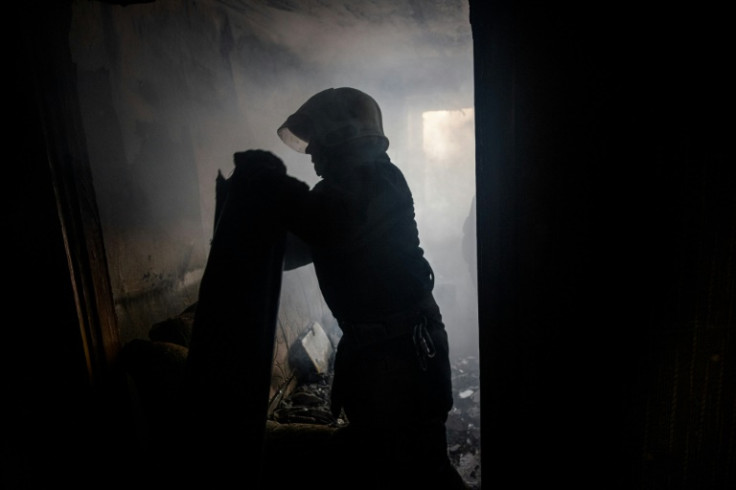 A Ukrainian firefighter removes a piece of a MLRS BM-27 Uragan missile from an apartment in Bakhmut on October 29