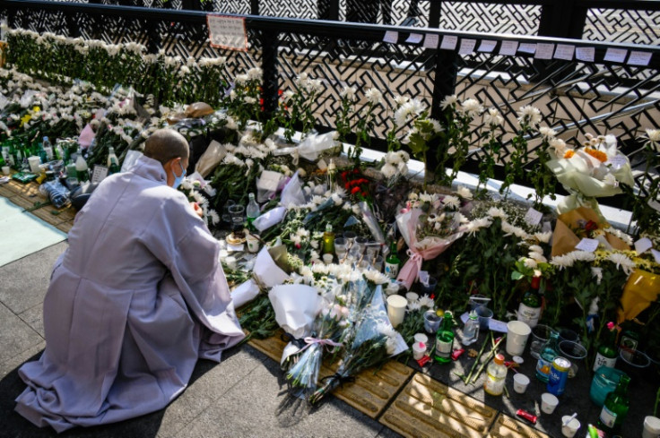 At a makeshift memorial close to the narrow alleyway at the epicenter of the disaster, Buddhist monks chanted prayers for the dead