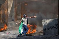 Palestinian protesters hurl rocks amid clashes with Israeli security forces in Hebron in the occupied West Bank, on October 30, 2022