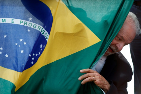 Luiz Inacio Lula da Silva, Brazil's former and newly elected president, appears behind a Brazilian national flag during a campaign rally in Sao Mateus on October 17, 2022