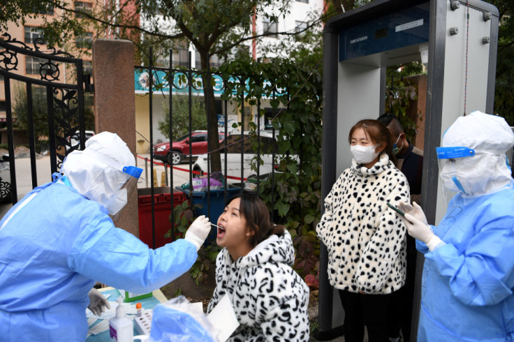 Medical worker collects a swab from a resident at a nucleic acid testing site in Lanzhou