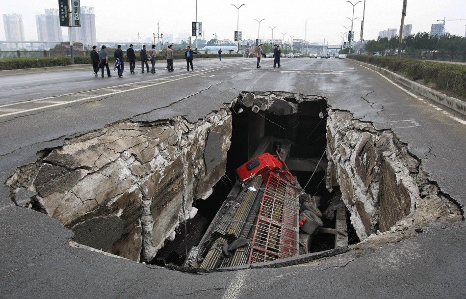 A truck is seen in a hole after part of the structure of a bridge collapsed in Changchun
