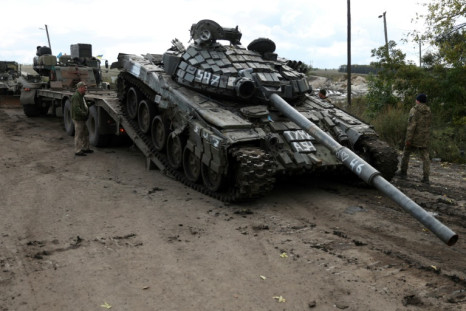 A Russian T-72 tank is loaded on a truck by Ukrainian soldiers outside the town of Izyum on September 24, 2022