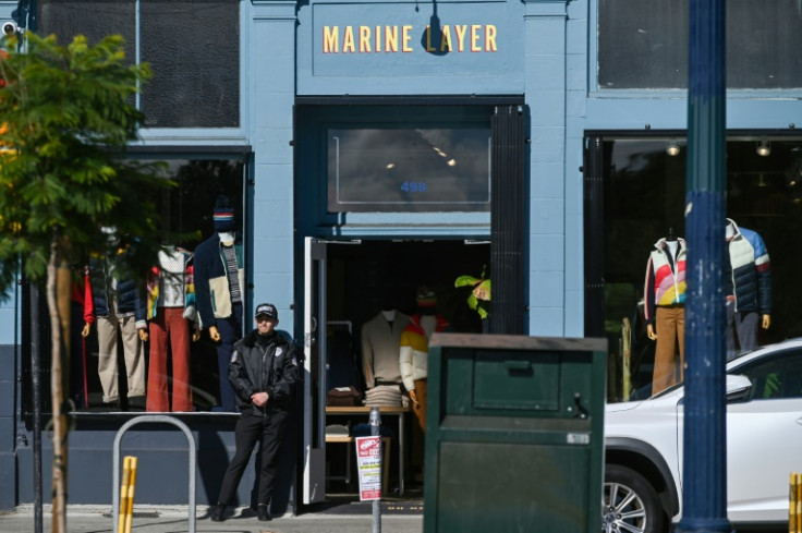 A private security guard stands in front of a  store in the Hayes Valley neighborhood of San Francisco