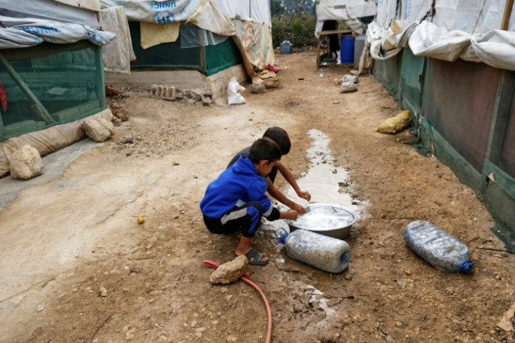 Amid an outbreak of cholera in the region, children rinse their hands at a camp for Syrian refugees in Talhayat, Lebanon