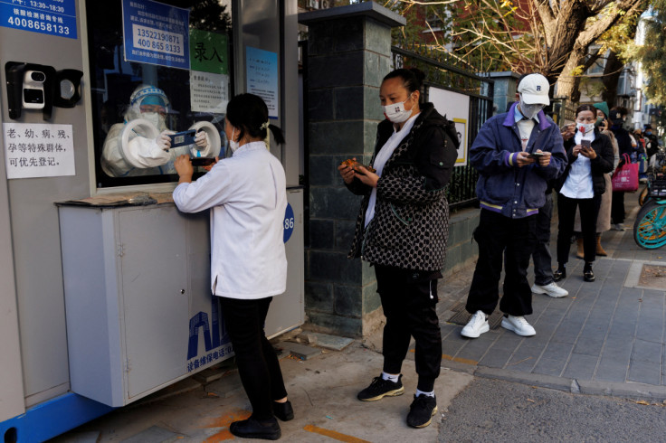 People line up to register their personal details before getting a swab test at a testing booth, as outbreak of the coronavirus disease (COVID-19) continue in Beijing