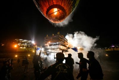 Participants release a hot-air balloon with fireworks attached
