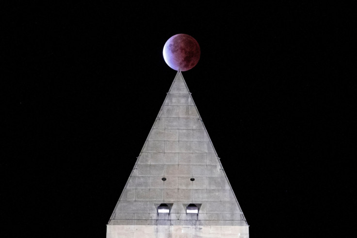The "Beaver blood moon" partial lunar eclipse is seen above the Washington Monument