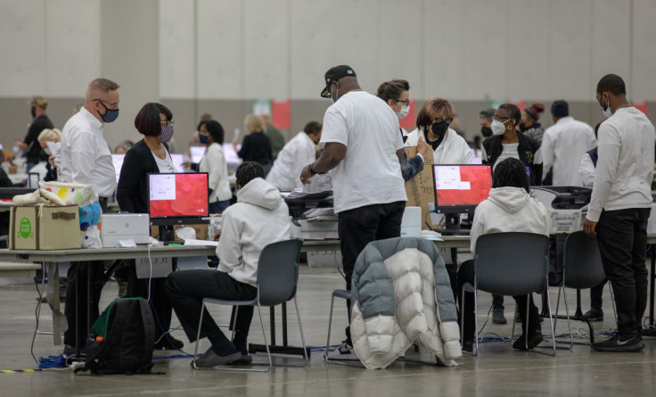 Detroit election workers feed absentee ballots into the tabulation machines during midterm elections