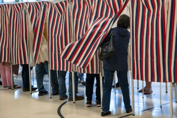 Time to choose -- A voter enters a booth at Parker-Varney Elementary School in Manchester, New Hampshire