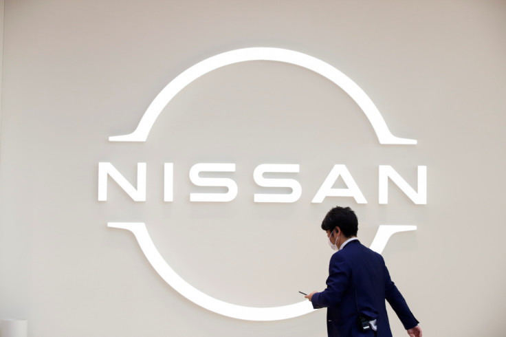 Man walks in front of the Nissan logo at Nissan Gallery in Yokohama
