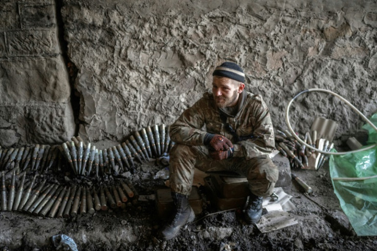 A Ukrainian soldier sits near ammunition in Bakhmut, eastern Ukraine